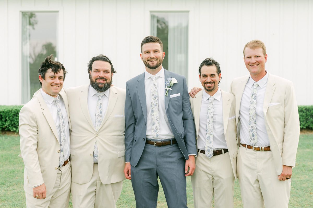 groomsmen in cream suits outside The Farmhouse chapel