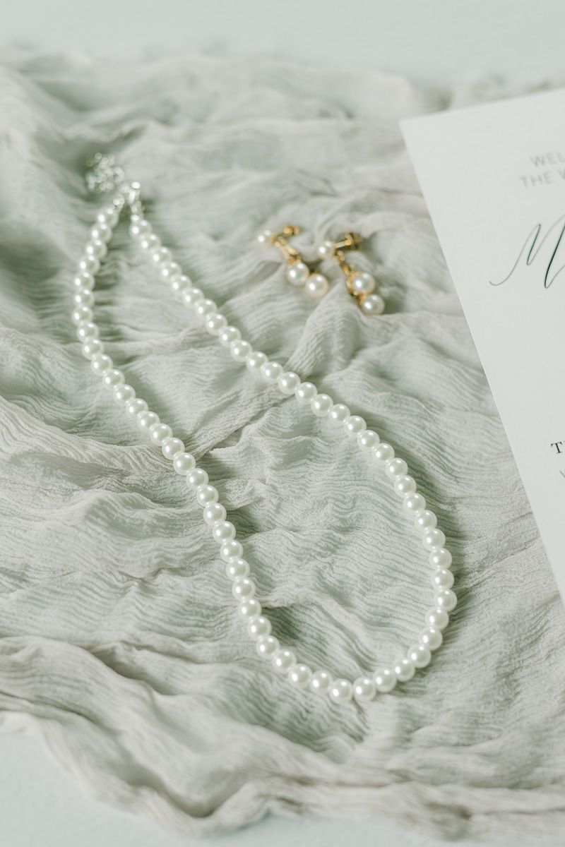 bride's necklace and earrings on grey fabric