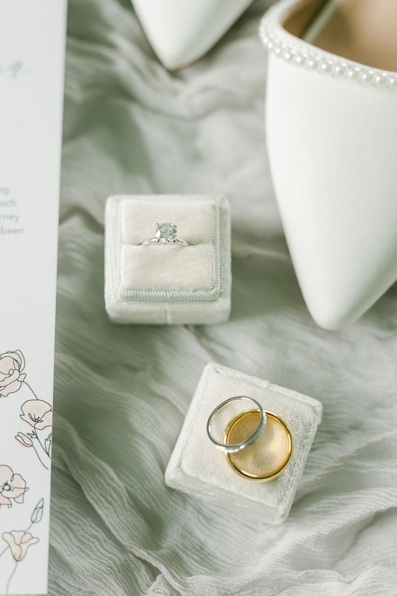 wedding rings in white box on grey fabric
