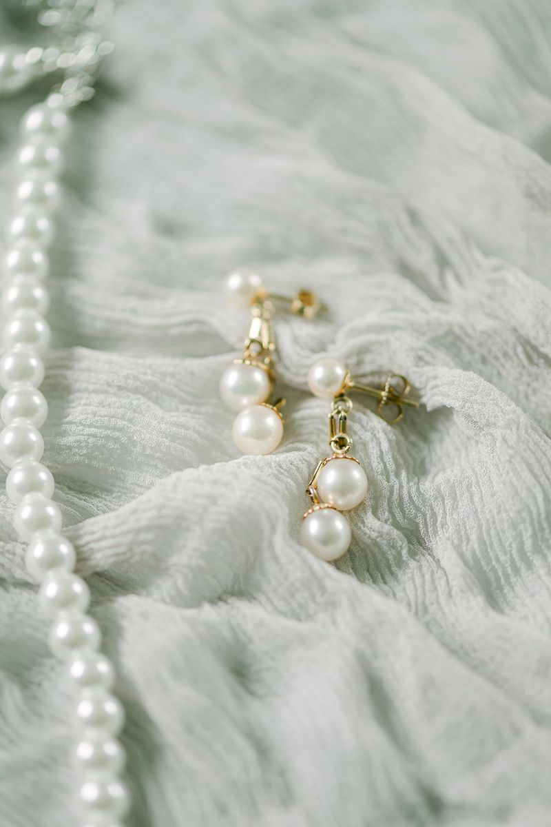 bride's earrings on grey fabric