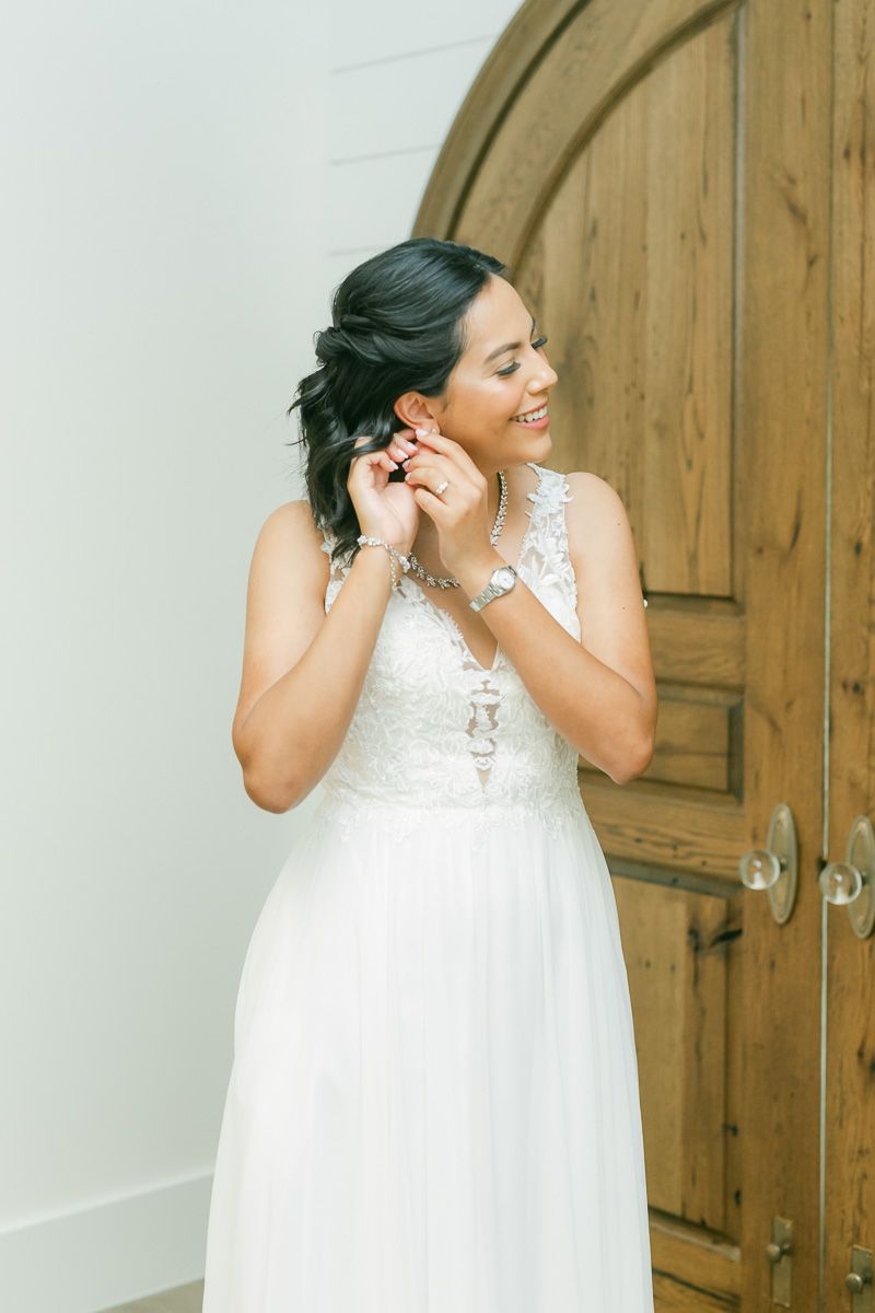 bride getting into dress at The Blue Magnolia wedding venue