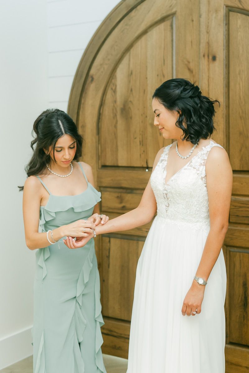 bride getting into dress at The Blue Magnolia wedding venue
