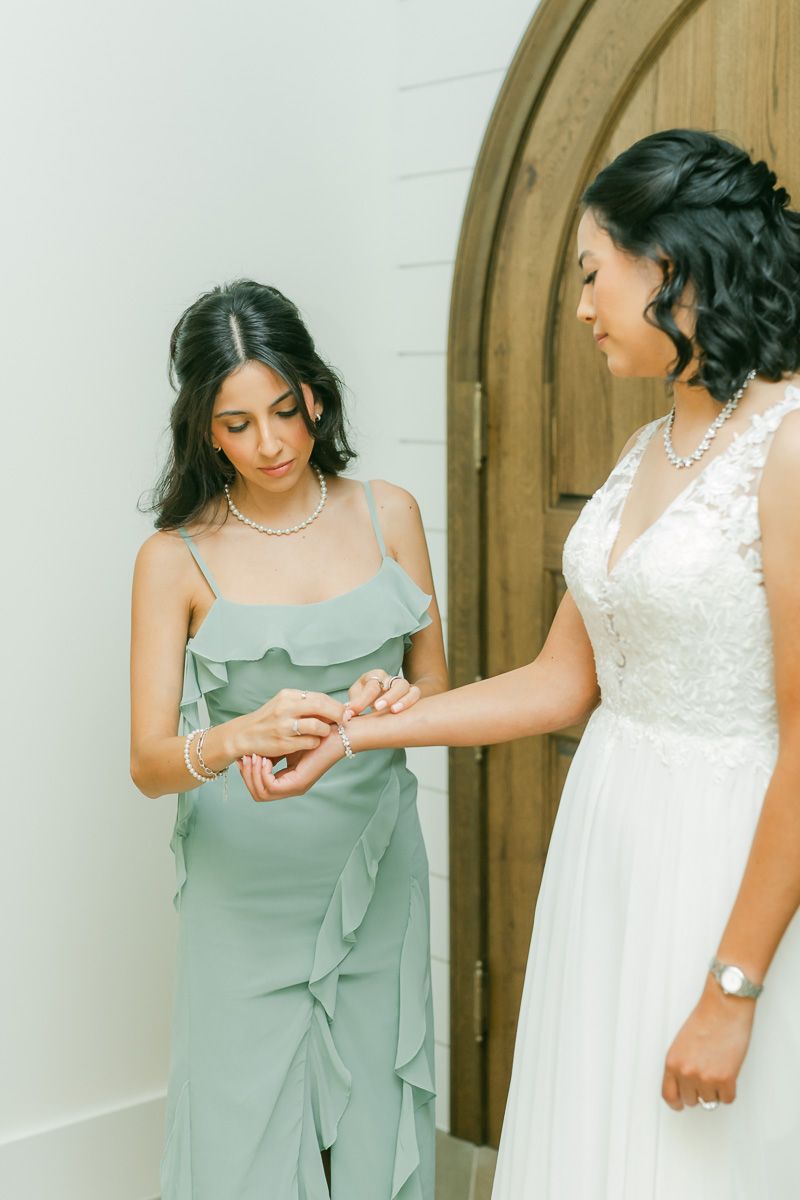 bride getting into dress at The Blue Magnolia wedding venue