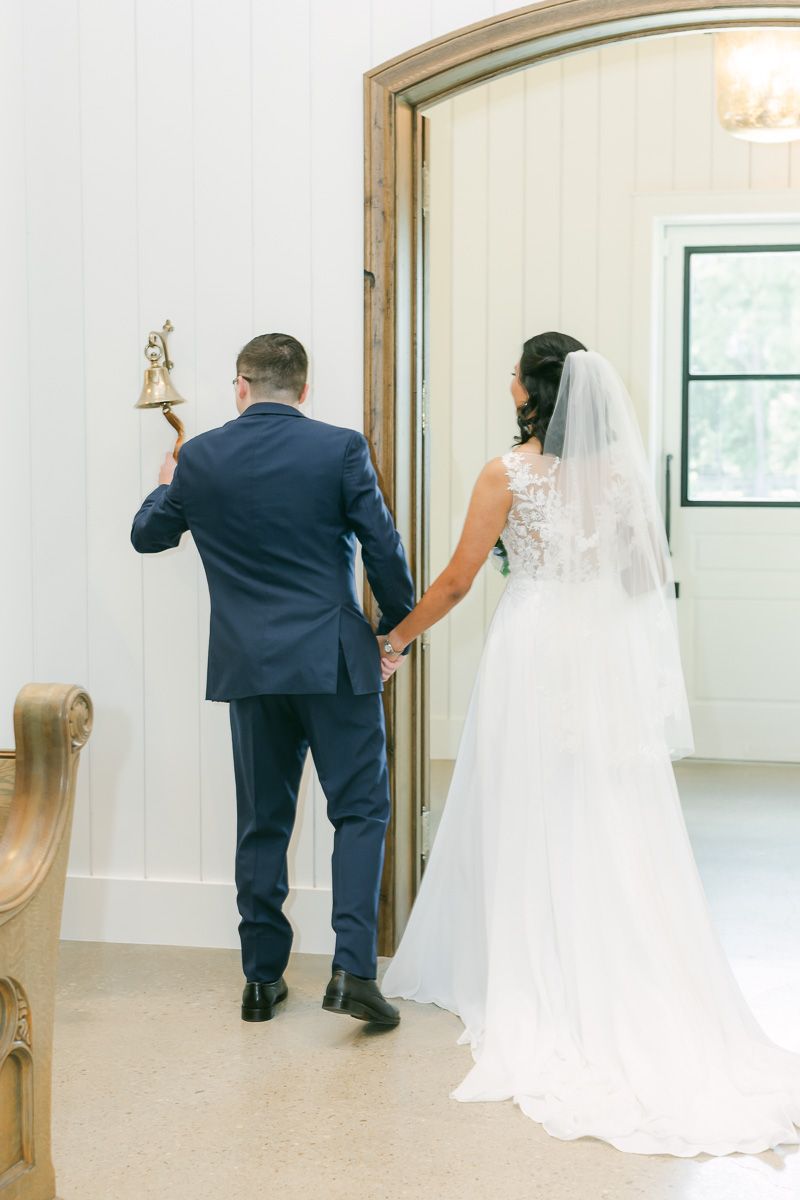 couple ringing bell after wedding ceremony