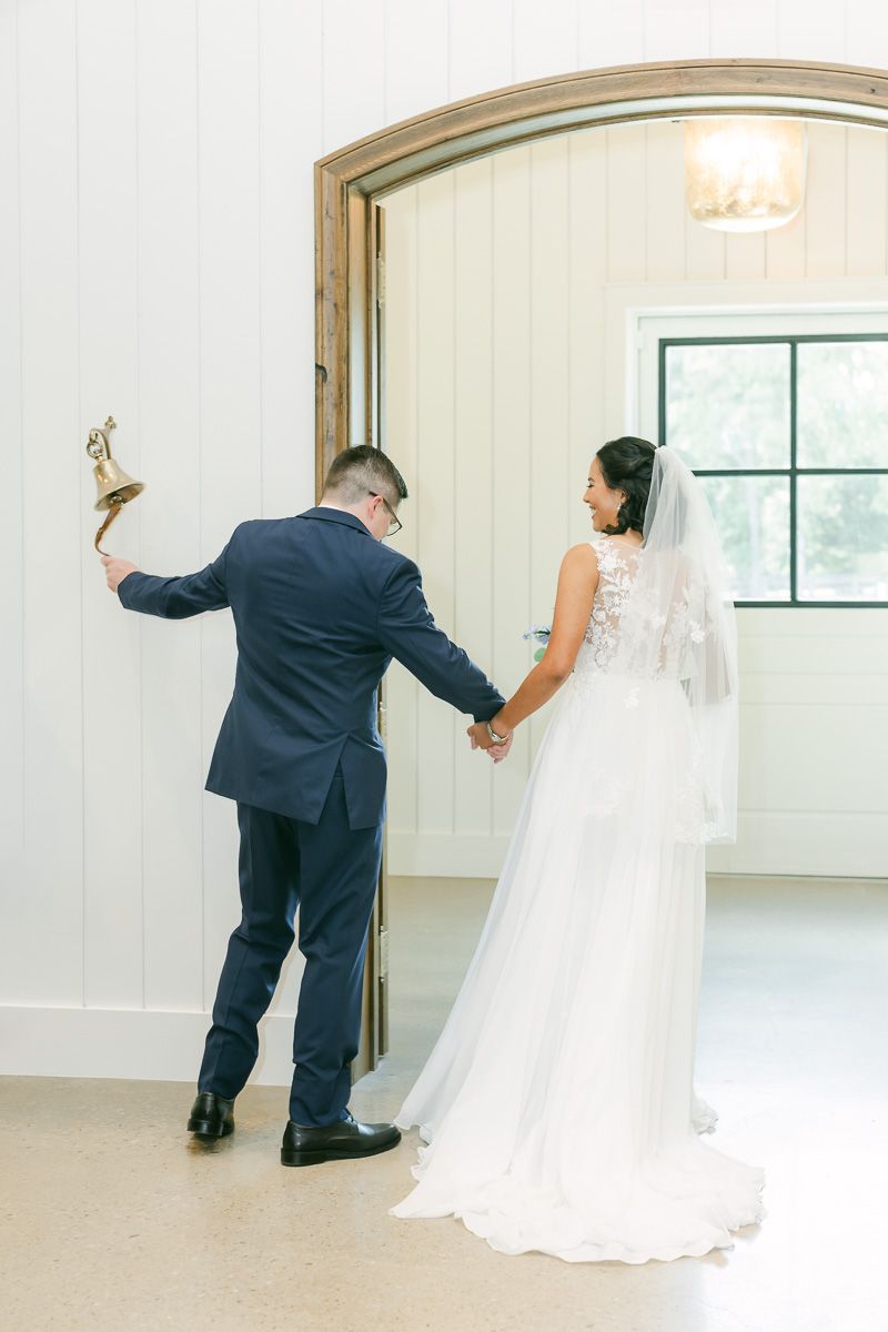 couple ringing bell after wedding ceremony