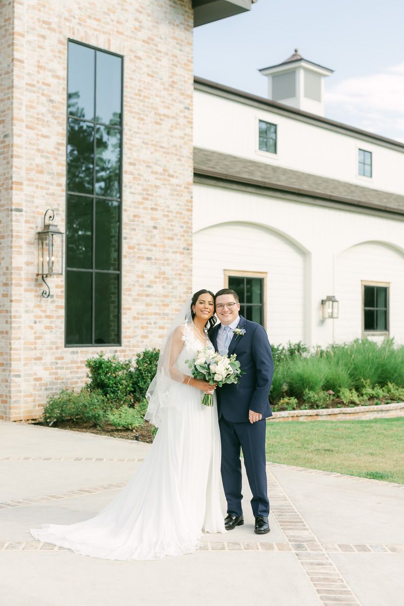 bride and groom in front of The Blue Magnolia wedding venue