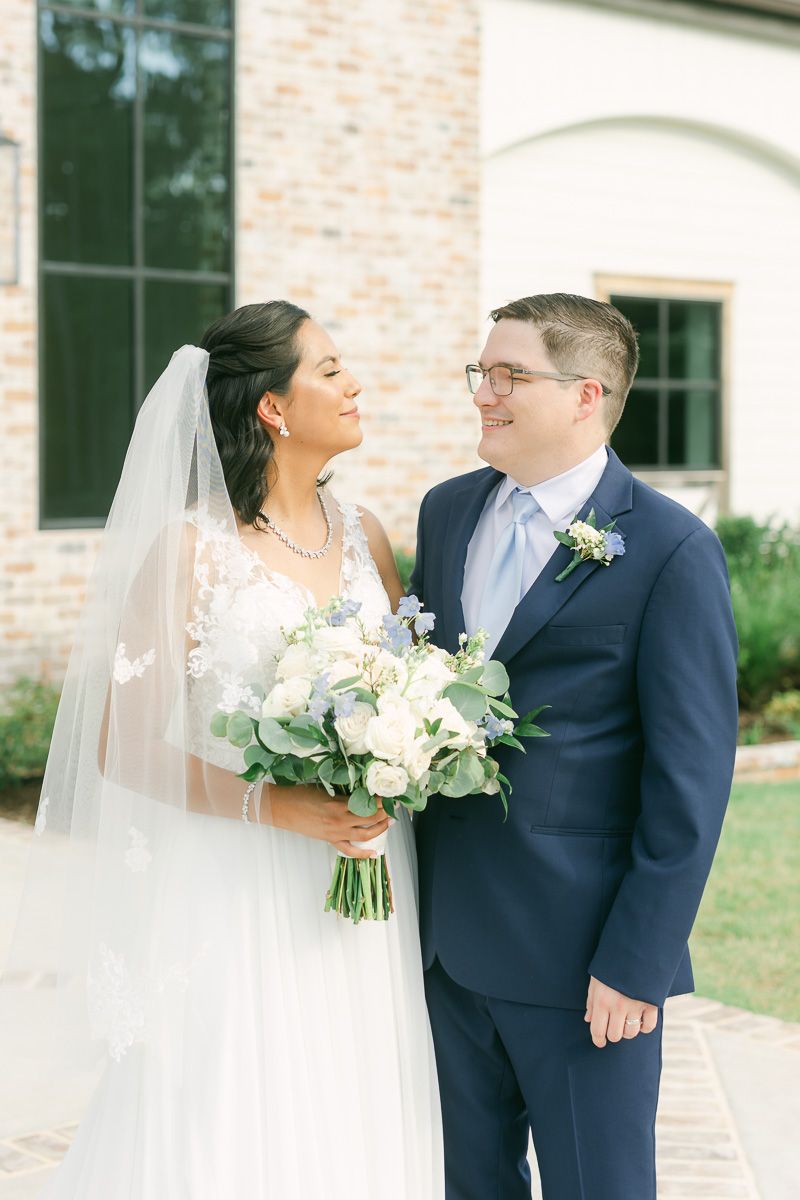 bride and groom in front of The Blue Magnolia wedding venue
