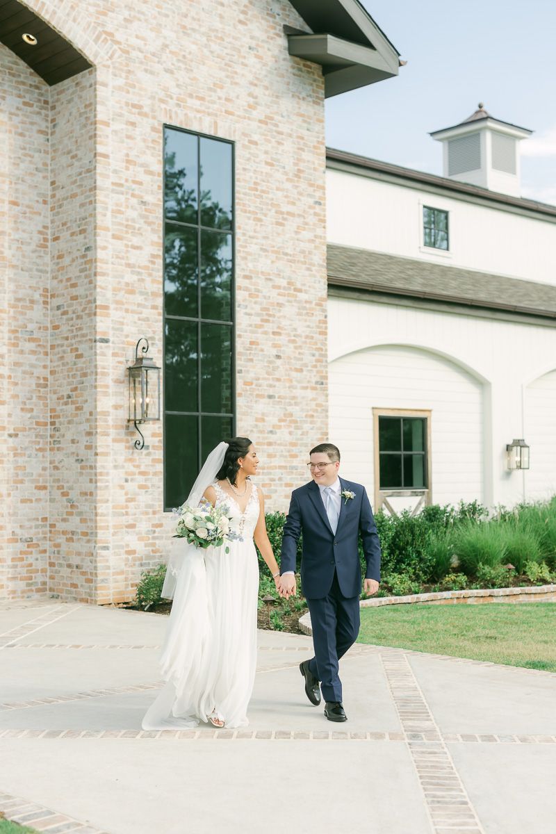 bride and groom walking in front of The Blue Magnolia wedding venue